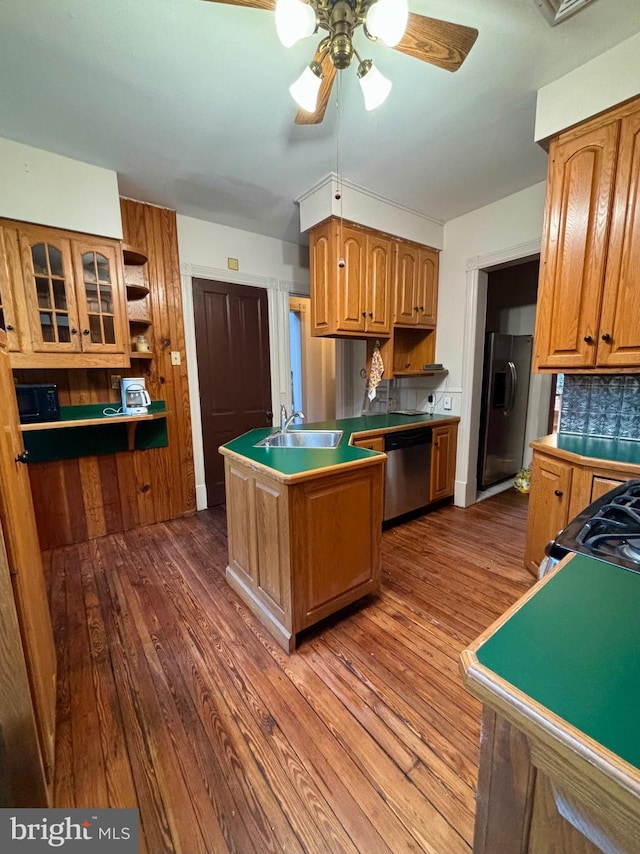 kitchen with backsplash, sink, stainless steel appliances, and wood-type flooring