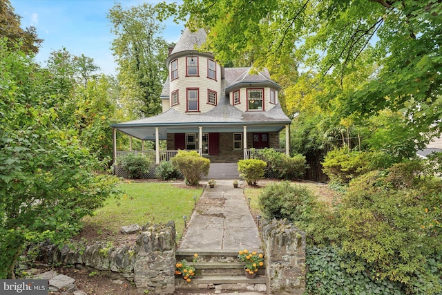 victorian house with covered porch and a front lawn