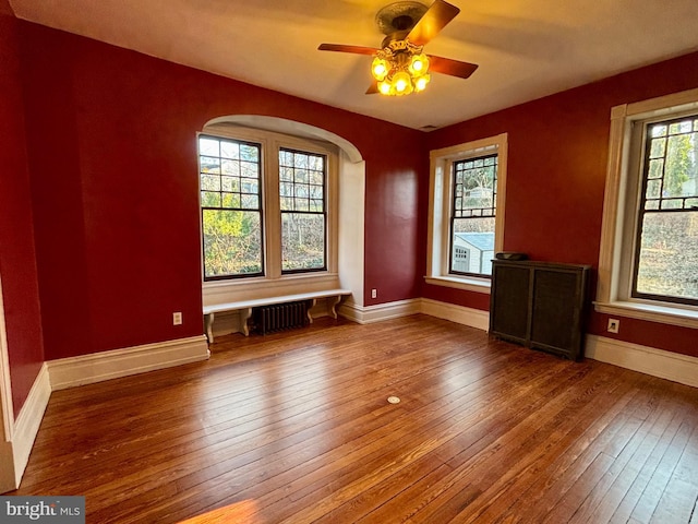 1250 Ashbourne Rd, Elkins Park, PA 19027 - spare room featuring hardwood / wood-style floors, ceiling fan, radiator heating unit, and arched walkways