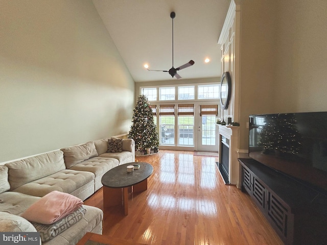 living room featuring light wood-type flooring, high vaulted ceiling, and ceiling fan