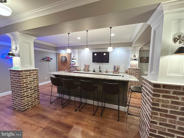 bar featuring white cabinets, dark hardwood / wood-style floors, light stone counters, and hanging light fixtures