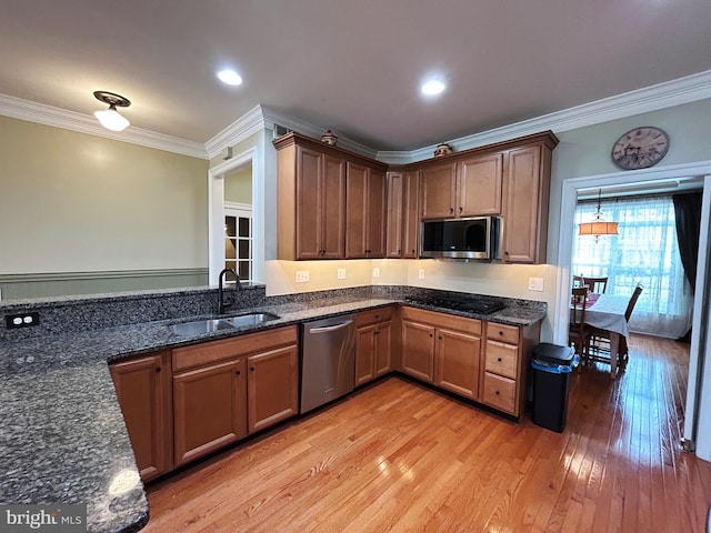 kitchen featuring crown molding, sink, stainless steel appliances, and light hardwood / wood-style floors