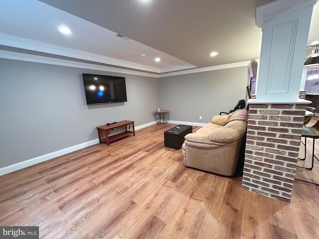 living room with crown molding and light hardwood / wood-style flooring