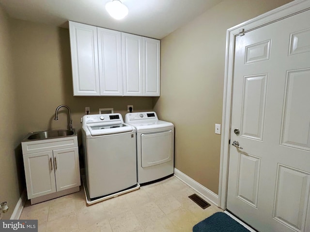 washroom featuring cabinets, sink, and washing machine and clothes dryer