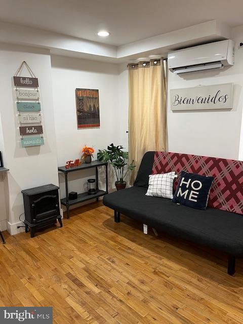 living room with hardwood / wood-style floors and a wall mounted AC