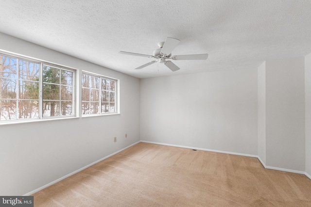 carpeted spare room featuring ceiling fan and a textured ceiling