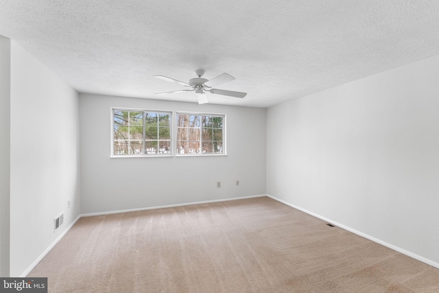 unfurnished room with a textured ceiling, carpet floors, and ceiling fan