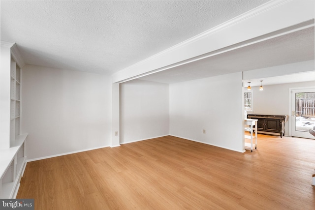 unfurnished living room with light hardwood / wood-style floors and a textured ceiling