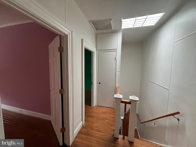 corridor featuring wood-type flooring and ornamental molding