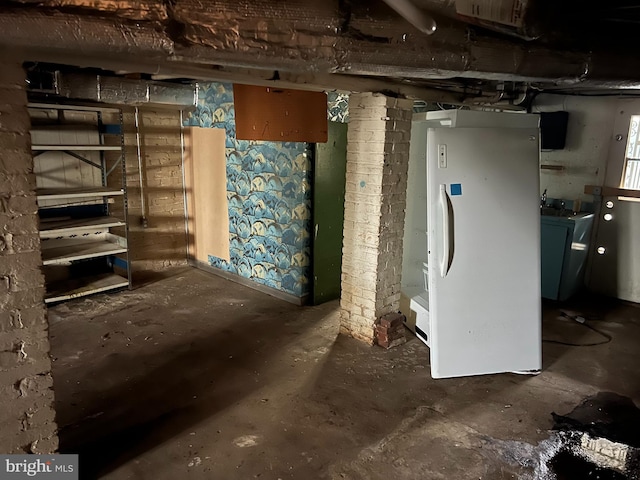 basement with washer / dryer and white refrigerator