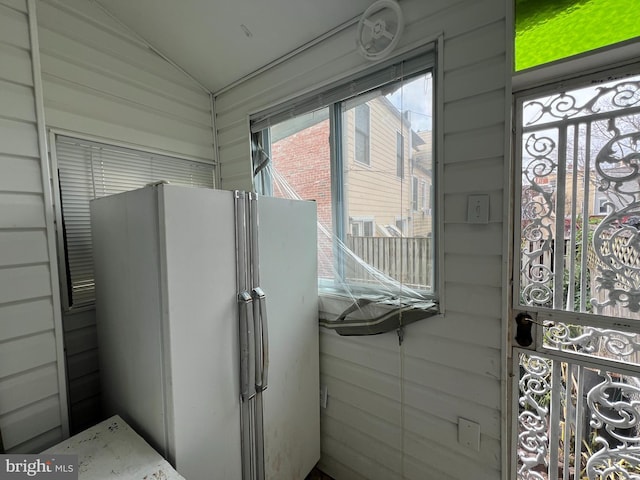 interior space featuring wood walls and white fridge