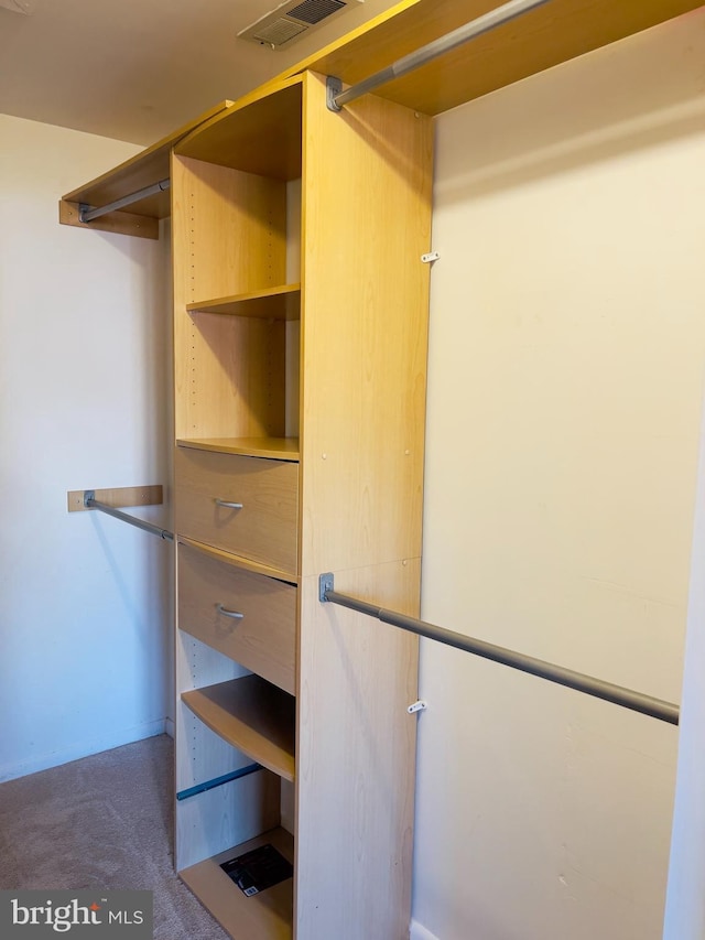 walk in closet featuring dark carpet