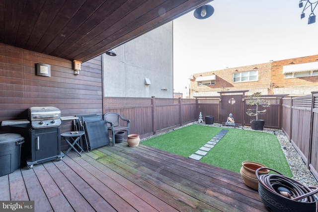 wooden deck with a grill and a yard