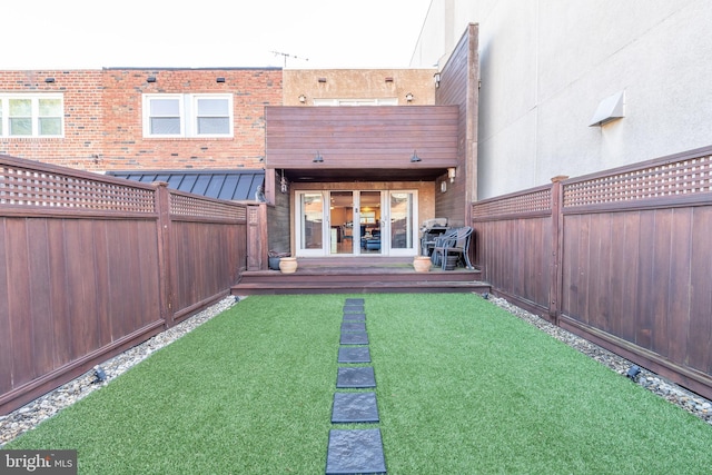 back of house featuring a lawn and a wooden deck