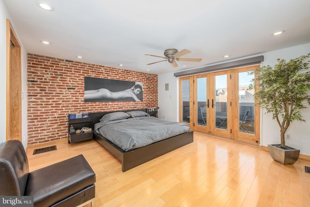 bedroom featuring access to exterior, ceiling fan, brick wall, and light wood-type flooring