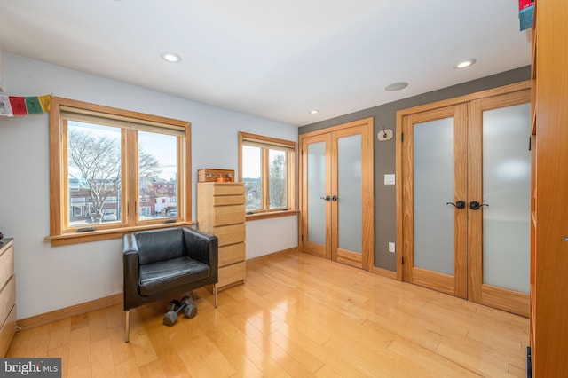 living area featuring light wood-type flooring and french doors