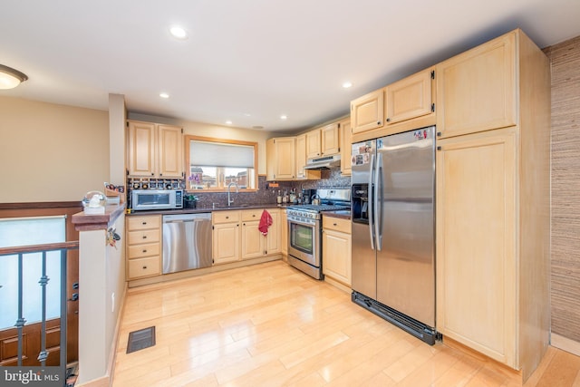 kitchen with light hardwood / wood-style floors, light brown cabinetry, sink, and appliances with stainless steel finishes