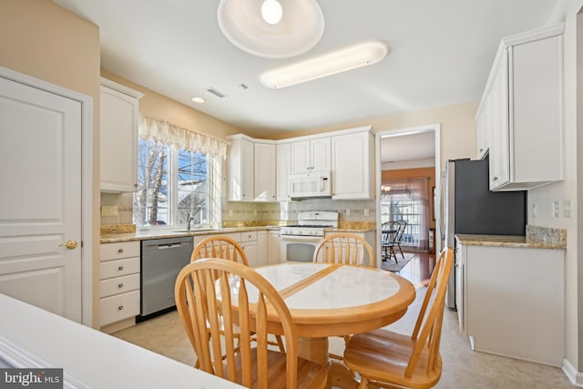 kitchen with white cabinets, decorative backsplash, appliances with stainless steel finishes, and sink