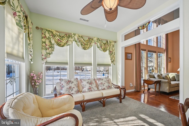 living room featuring ceiling fan and dark wood-type flooring