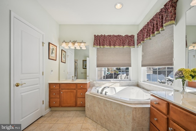 bathroom featuring tiled tub, tile patterned floors, and vanity