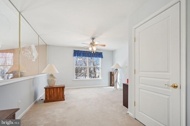 interior space with ceiling fan and light colored carpet