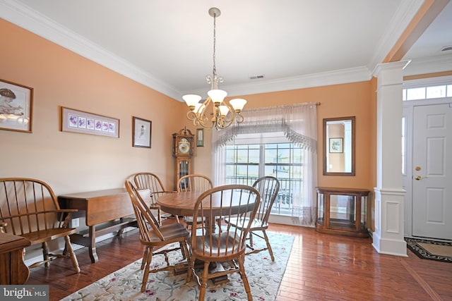 dining area featuring a chandelier, crown molding, dark hardwood / wood-style flooring, and decorative columns