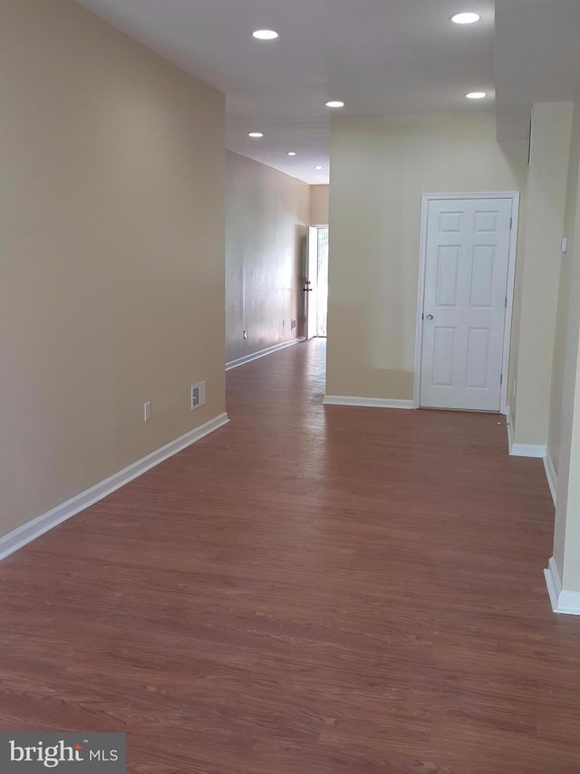 unfurnished room with dark wood-type flooring