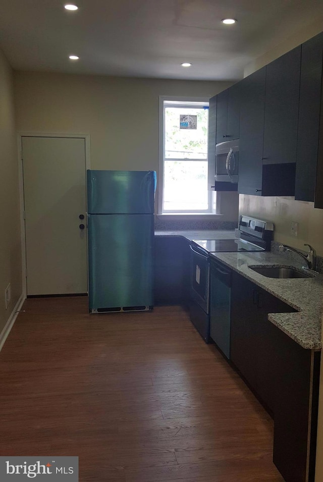 kitchen featuring dark wood-type flooring, light stone countertops, sink, and stainless steel appliances