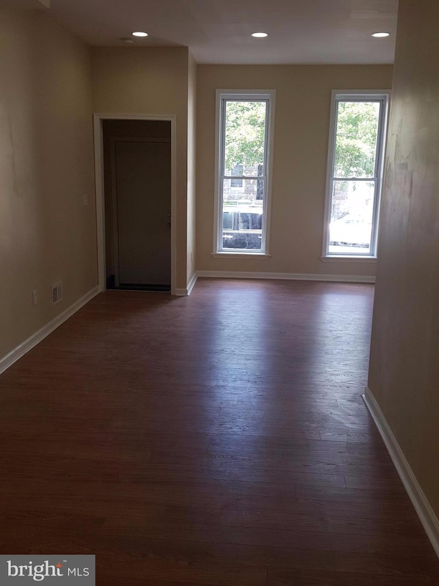 unfurnished room featuring dark wood-type flooring