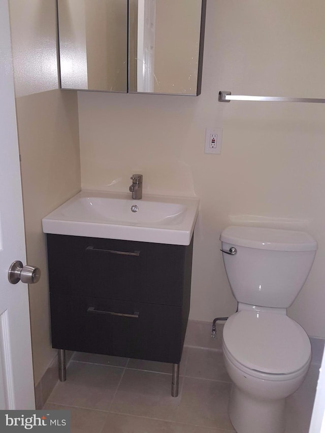 bathroom featuring toilet, vanity, and tile patterned floors