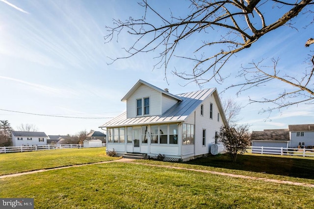 view of front facade featuring a sunroom and a front yard