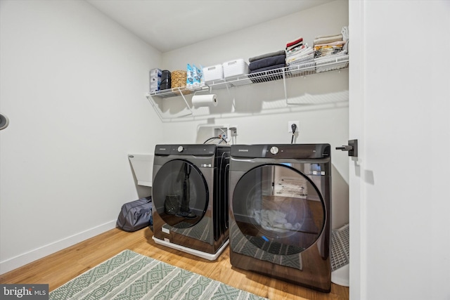 washroom with hardwood / wood-style floors and washer and dryer