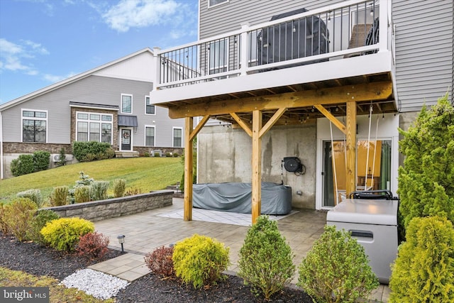 rear view of property featuring a patio area and a lawn