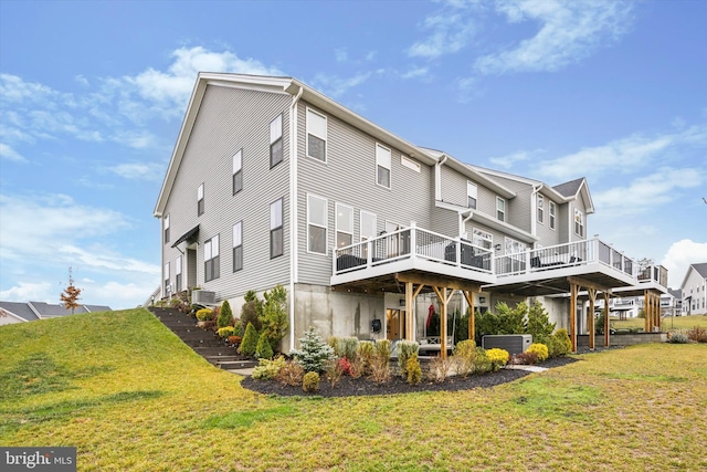 rear view of house featuring a lawn, cooling unit, and a deck