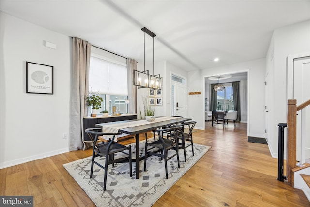 dining space with light hardwood / wood-style flooring and a chandelier