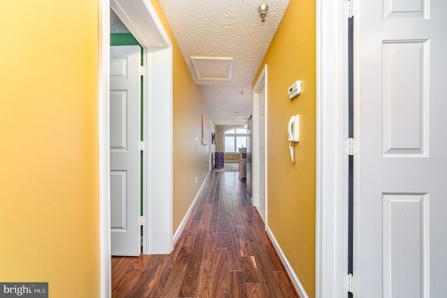 corridor featuring dark hardwood / wood-style floors and a textured ceiling