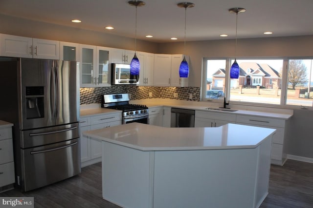 kitchen with appliances with stainless steel finishes, white cabinetry, dark wood-type flooring, and sink