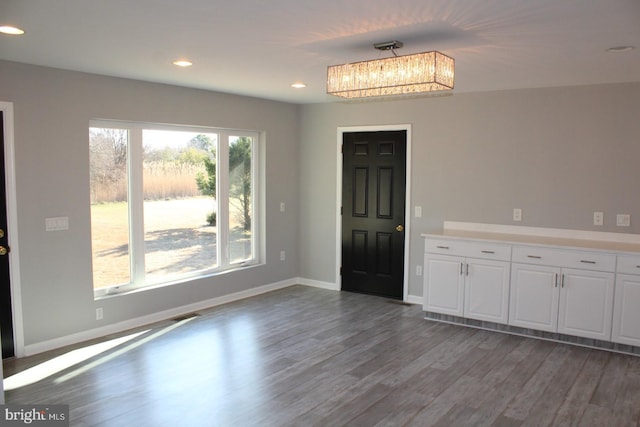 entrance foyer with hardwood / wood-style floors and a notable chandelier