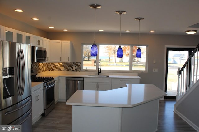 kitchen with white cabinets, a kitchen island, sink, and stainless steel appliances