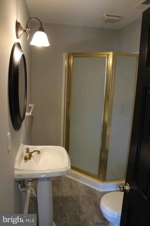 bathroom featuring sink, hardwood / wood-style floors, an enclosed shower, and toilet