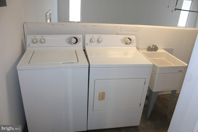 clothes washing area featuring dark hardwood / wood-style flooring, independent washer and dryer, and sink