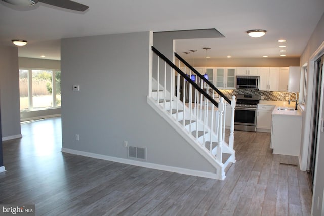 stairway featuring sink and wood-type flooring