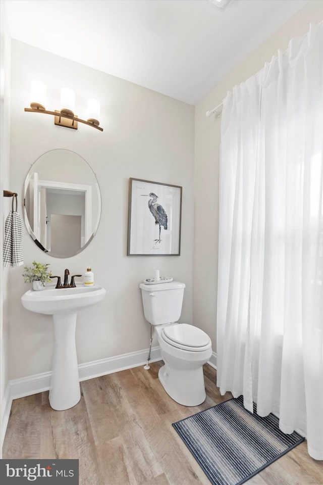 bathroom with wood-type flooring and toilet