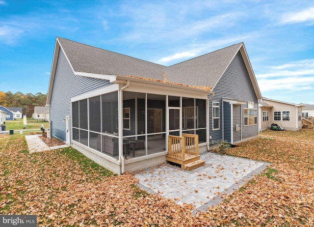 back of property with a patio and a sunroom