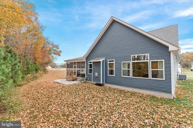 rear view of property featuring a sunroom and central AC unit