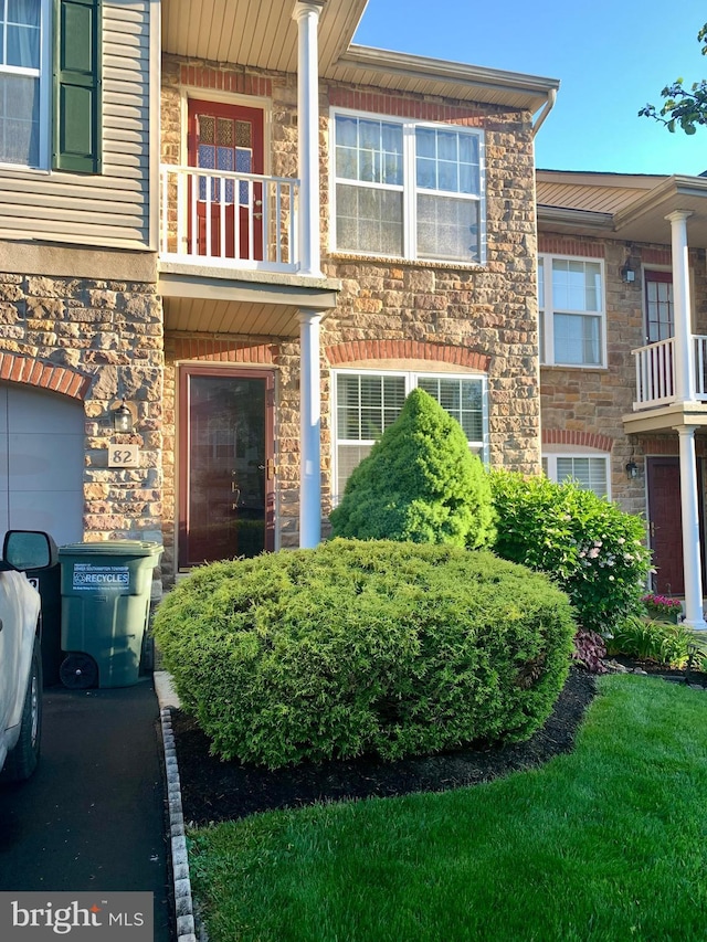 view of front of home featuring a balcony and central AC unit