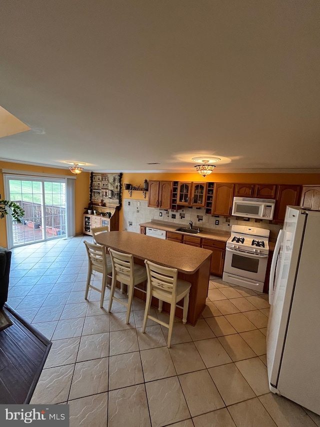 kitchen with a center island, light tile patterned flooring, white appliances, and sink