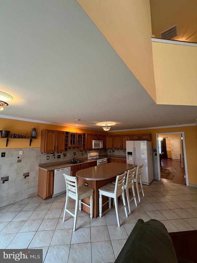 dining area with crown molding, sink, and light tile patterned floors