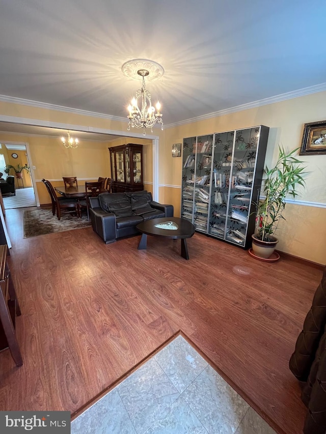 living room featuring wood-type flooring, an inviting chandelier, and ornamental molding