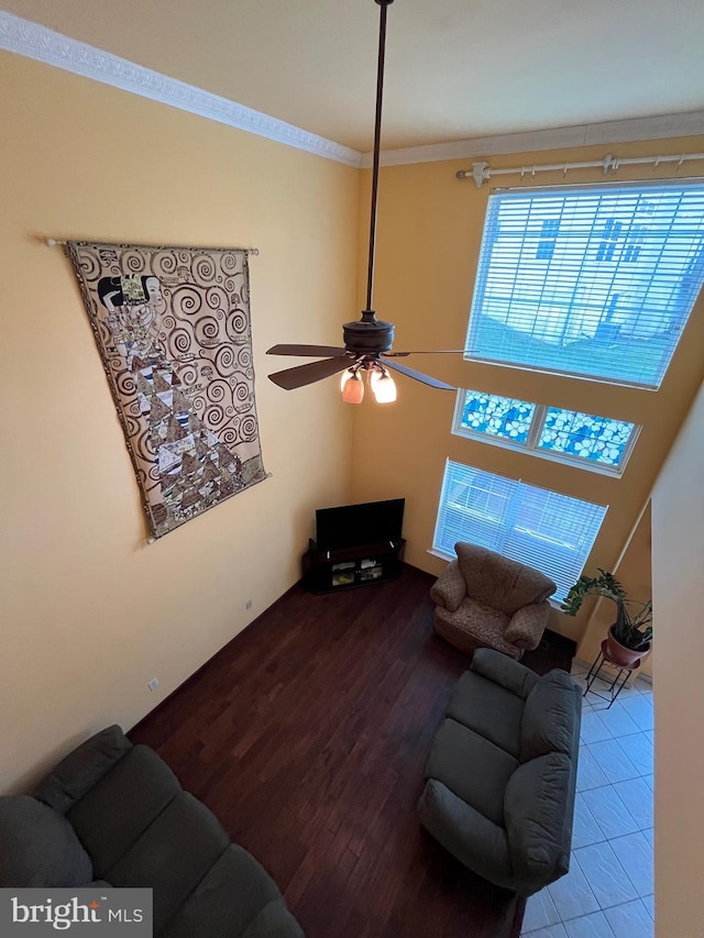 living room with hardwood / wood-style floors, ceiling fan, and ornamental molding